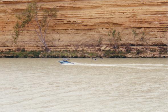 Kirsty driving the motorboat.  Love the cliff.